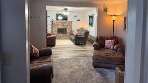 A living room with two sofas, a fireplace, and a television.