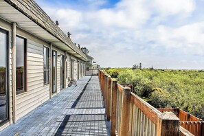 A wooden deck with a view of dense greenery. - Ocean Surf Condo | Deck | Water View | Unit 206 (Ocean Shores)