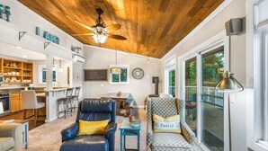A spacious living room with a ceiling fan, a dining area, and a kitchen. - Lakefront House: Private Dock, Forest Views, (Shelton)
