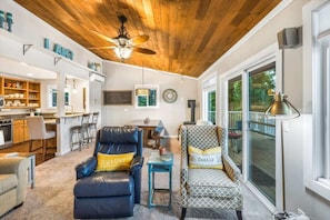 A spacious living room with a ceiling fan, a dining area, and a kitchen.