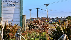 Une enseigne de l’hôtel Maris Stella, avec une clôture en bois rustique et des plantes d’agave au premier plan.