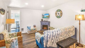 Ein Wohnzimmer mit Kamin, Fernseher und einer Couch.