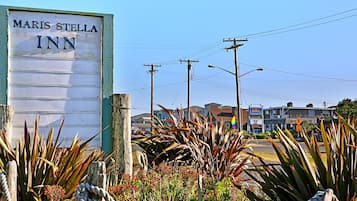 Letrero del Maris Stella Inn, con una cerca de madera rústica y plantas de agave al frente.