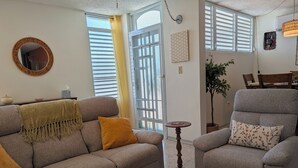 A living room with a sofa, armchair, wooden coffee table, and a small round table. - Sun Seekers Retreat-Beaches• Ferry• Cold A/C• Fast WiFi (Santa María)