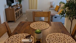 A dining area with a wooden table, woven placemats, and a ceiling fan. - Sun Seekers Retreat-Beaches• Ferry• Cold A/C• Fast WiFi (Santa María)
