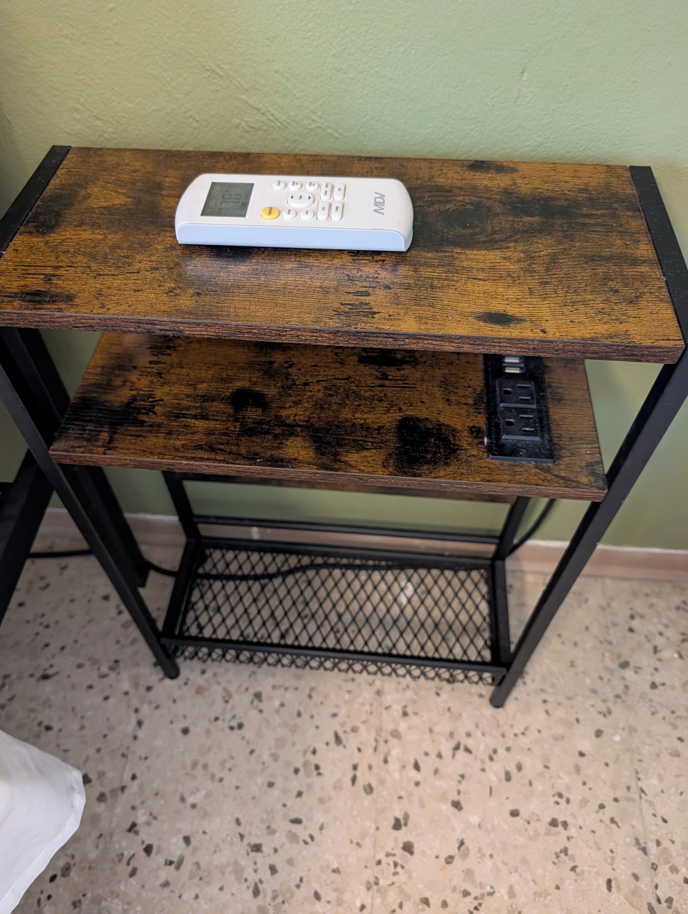 A wooden desk with a white electronic device on top.