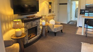 Olohuone, jossa on takka, televisio ja ruokailutila.