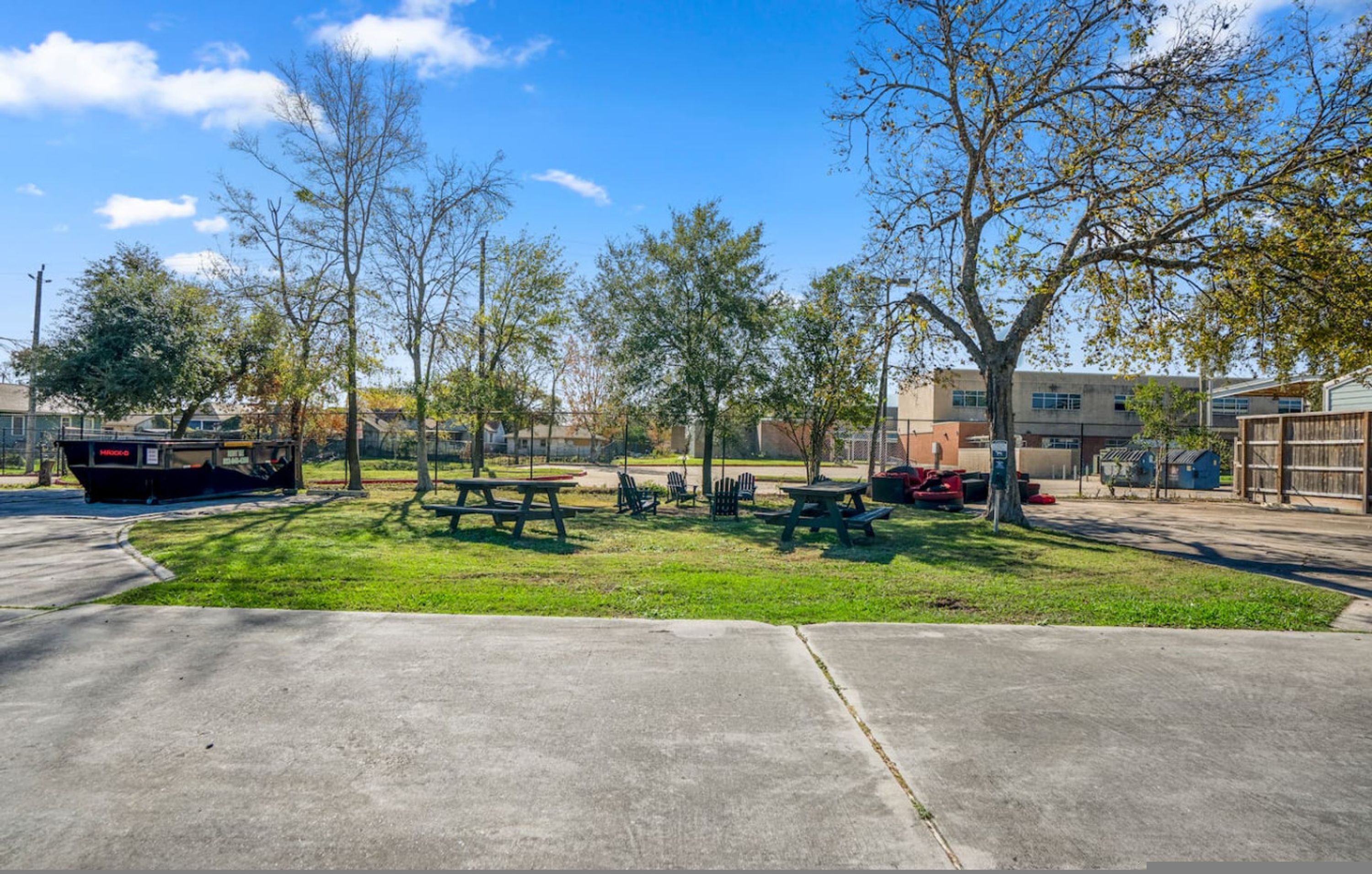 Ein Park mit Picknicktischen und -stühlen, einem Boot und Bäumen.
