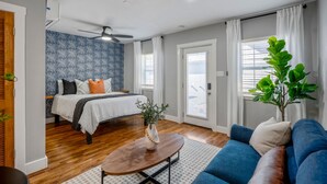 A bedroom with a bed, a ceiling fan, and a window with curtains. - Urban Studio Retreat Near Downtown Houston (Houston)