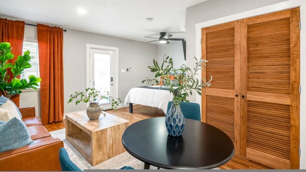 A room with a bed, a desk, a chair, a table, and a potted plant. - Stylish Studio Near Downtown Attractions (Houston)