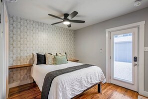 A bedroom with a bed, a ceiling fan, a window, and a door. - East End Studio Close to Houston Hotspots (Houston)