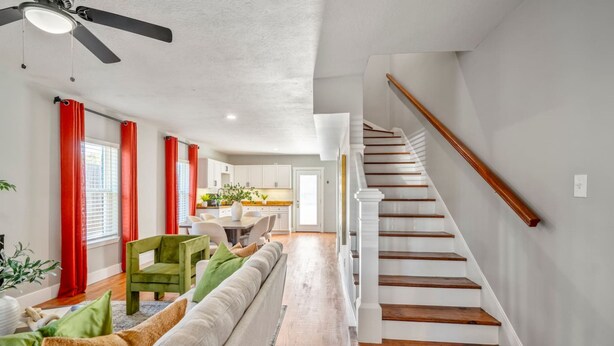 A modern living room with a staircase, a dining area, and a kitchen. - 2-bedroom - Equipped Kitchen - Gated Parking (Houston)