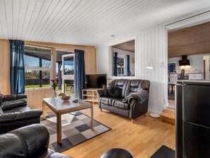 Ein modernes Wohnzimmer mit einer Ledersofa, einem Couchtisch und einem Fernseher.