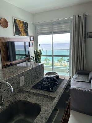 A kitchen with a view of the ocean, a dining area, and a living space. - 180-degree sea view (Salvador)