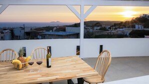 A wooden table with chairs, a fruit bowl, and wine glasses. - Thea Villa (Faistos)