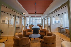 A modern meeting room with glass walls, a central table, and comfortable seating. - Corner 2BR with Skyline Views and Rooftop Pool Minutes to South Beach, Brickell and Wynwood (Miami)