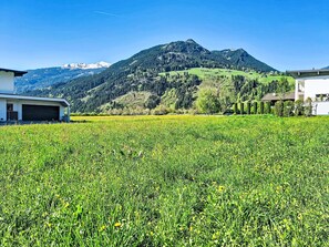 A field with a mountain in the background, a building with a garage, and a clear sky. - Apart Wurm by Interhome (Uderns)