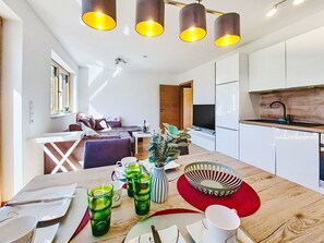 A modern kitchen with white cabinets, a wooden countertop, and a built-in oven. - Apart Wurm by Interhome (Uderns)