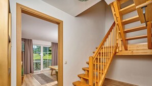 A wooden staircase leading to a balcony with a view of greenery. - Heckenrose mit Badewelt und Sauna inkl. by Interhome (Sankt Englmar)