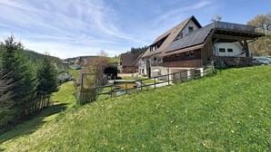 Ein Haus mit einem geneigten Dach, einer Veranda und einer kleinen Terrasse.