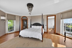 A bedroom with a four-poster bed, a large window with a city view, and a balcony. - Elegant 3 Bed Hampstead Flat (London)
