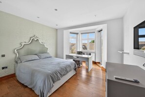 A bedroom with a bed, a desk, and a TV. - Elegant 3 Bed Hampstead Flat (London)