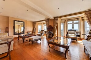 A spacious living room with a large mirror, a glass coffee table, and a sofa. - Elegant 3 Bed Hampstead Flat (London)