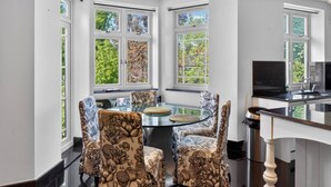 A modern kitchen with a glass table, patterned chairs, and large windows. - Elegant 3 Bed Hampstead Flat (London)