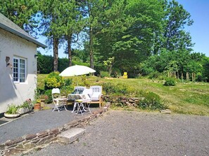 A house with a patio, outdoor furniture, and a garden. - Coin Nature by Interhome (Montpinchon)