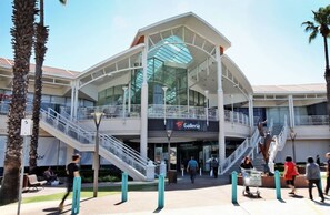 A modern building with a glass facade, a staircase, and a sign that reads 'Galeria.'