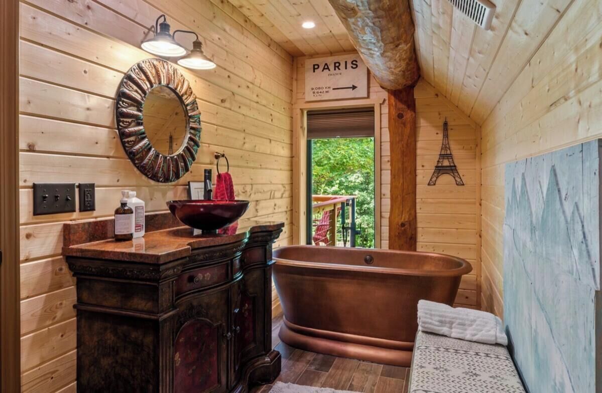 Een houten interieur met een bad, een spiegel en een bord waarop 'PARIS' staat.