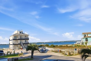 Ein mehrstöckiges Gebäude mit Blick auf den Strand, einem Parkplatz und einem Schild.