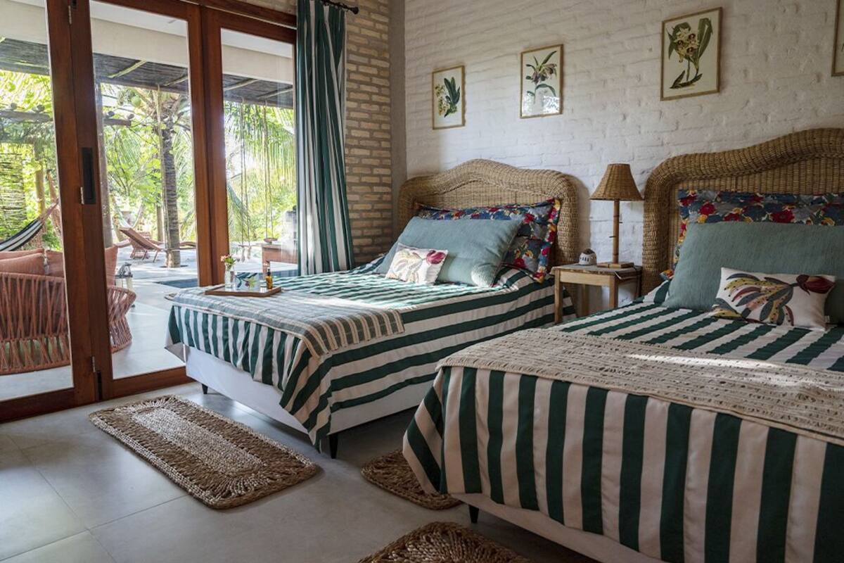 Una habitación con dos camas, un ventanal y vistas al exterior.
