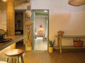 A kitchen with a wooden table, hanging baskets, and a potted plant. - Hotel Boutique Quinta Três Marias (Paracuru)