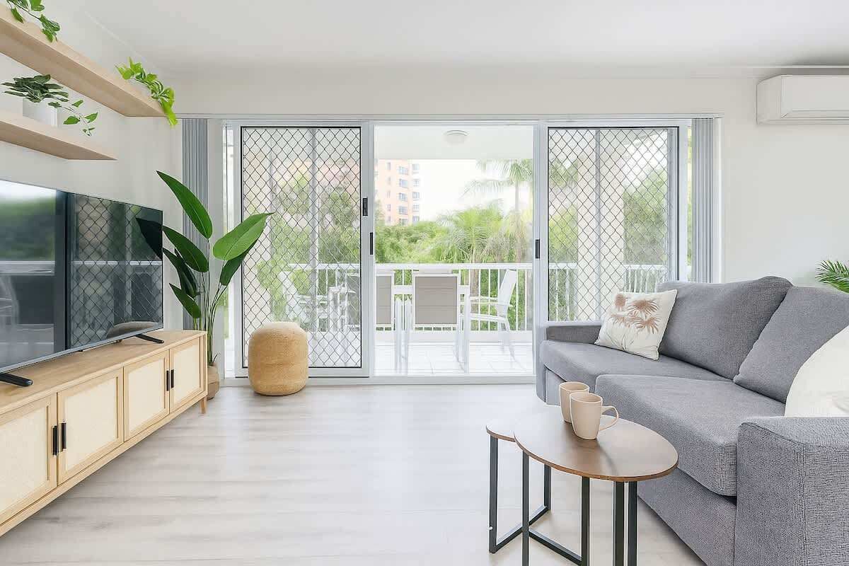 A modern living room with a sofa, TV, and a small table.