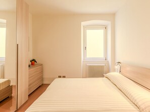 Ein Schlafzimmer mit Bett, Kommode und Fenster.