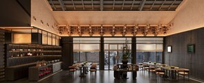 A restaurant with a dark interior, wooden ceiling, and a large window. - Happy Dragon Imperial Garden Courtyard  (Beijing)