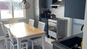 A modern kitchen with a dining table, chairs, a stove, and a refrigerator. - Beautiful peaceful house! (Rätan)