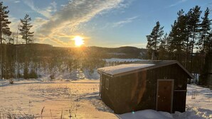 A wooden cabin in a snowy landscape with a clear sky and sunlight. - Beautiful peaceful house! (Rätan)