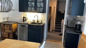 A compact kitchen with a sink, cabinets, and a dining area. - Beautiful peaceful house! (Rätan)