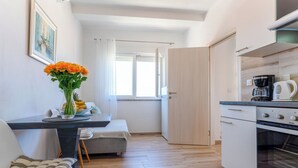Eine moderne Küche mit Essbereich, einer Kaffeemaschine und Blick ins Freie.
