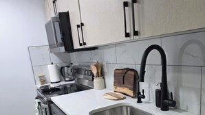 A modern kitchen with a stainless steel sink, a microwave, and a toaster.
