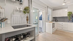 Une cuisine moderne avec des armoires blanches, un comptoir noir et une vue sur l’extérieur.