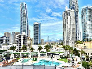 A modern urban area with high-rise buildings, a swimming pool, and palm trees. - L7 Ocean View Studio with 2 Beds+Netflix (Surfers Paradise)