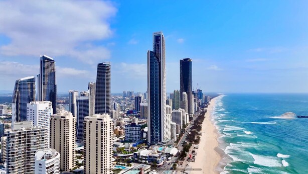 Eine Küstenstadt mit hohen Gebäuden, einem Strand und dem Meer.