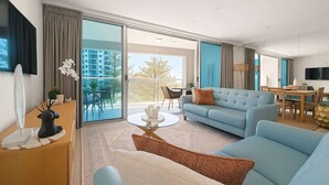 Ein modernes Hotelzimmer mit Balkon, einer Couch, einem Esstisch und einem Fernseher.