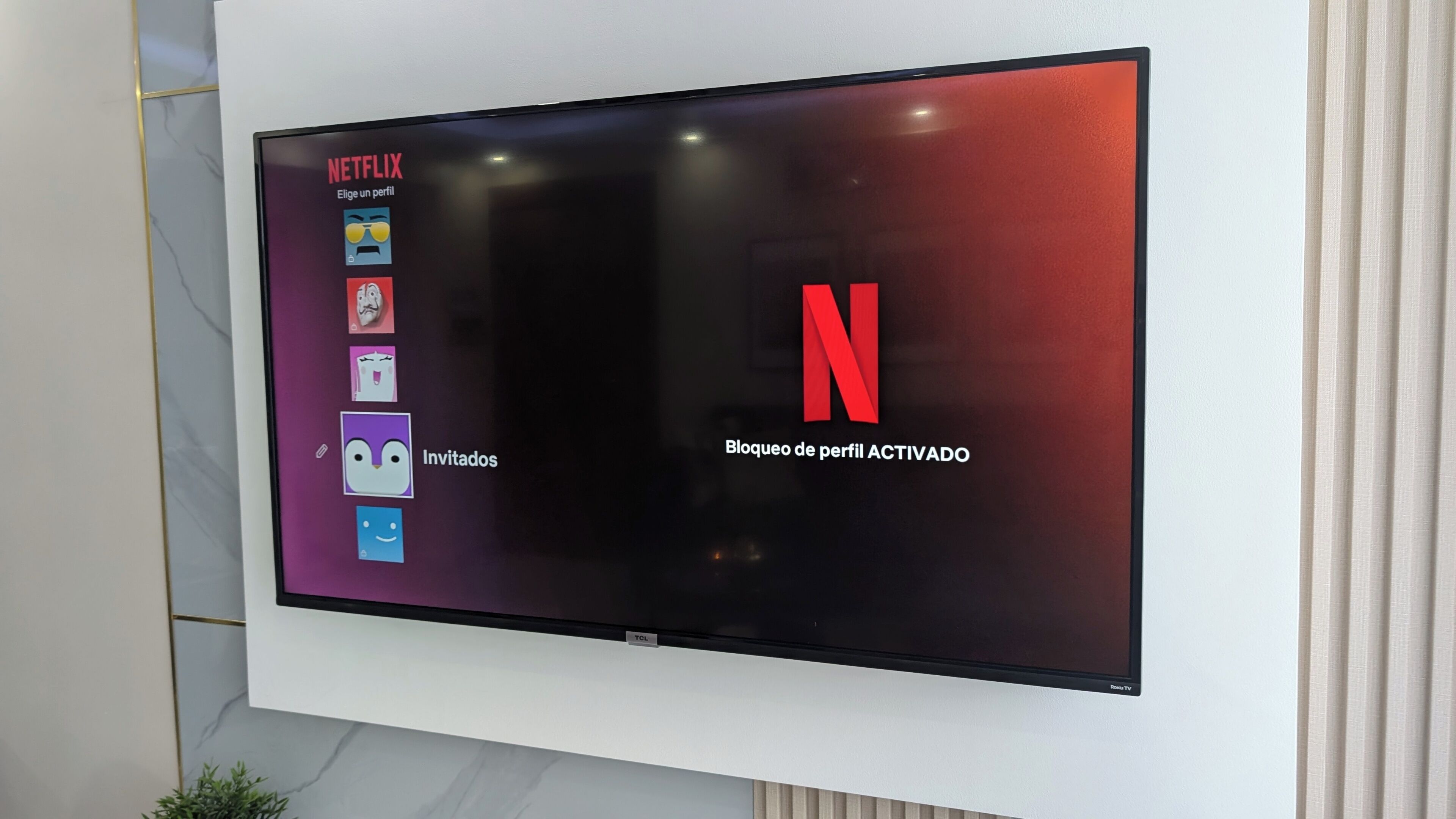 A television screen displaying the Netflix interface with profile options and a blocked profile notification.
