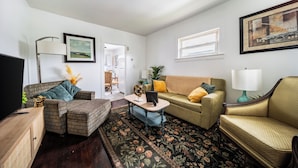 A living room with a sofa, armchair, coffee table, and a TV. - 10 min to University Circle - Central Location (Cleveland)