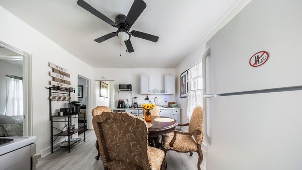 A modern kitchen with a dining area, a ceiling fan, and a sign on the wall. - 10 min to University Circle - Central Location (Cleveland)