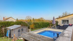 A backyard with a swimming pool, wooden deck, and a small shed. - Chalet-type house for 7 people with swimming pool near Disneyland Paris (EuroDisney) (Villiers-sur-Morin)